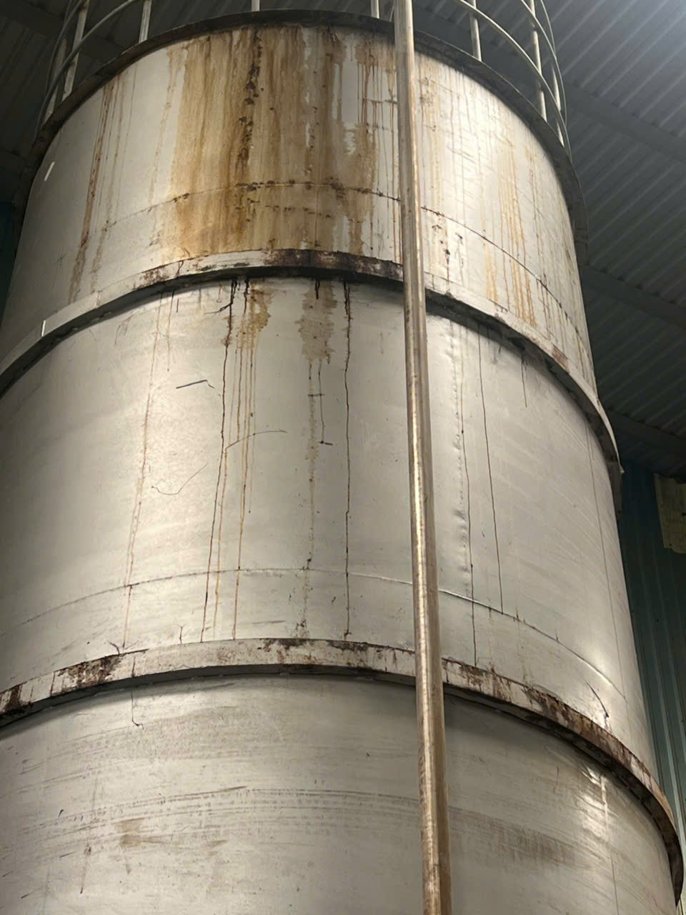 Mối hàn vành đai trên thân silo thép bị rỉ thành dải liên tục, lớp sơn cũ bong tróc