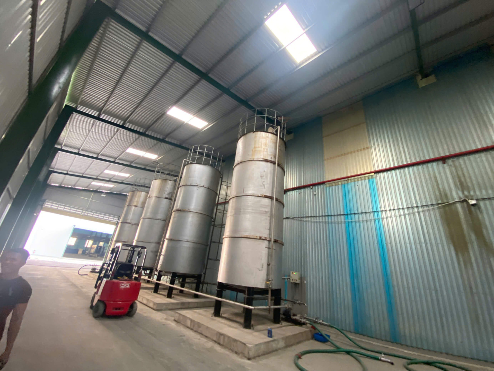 Dãy silo thép đặt trong nhà xưởng nhà máy chế biến, chân silo trên bệ bê tông