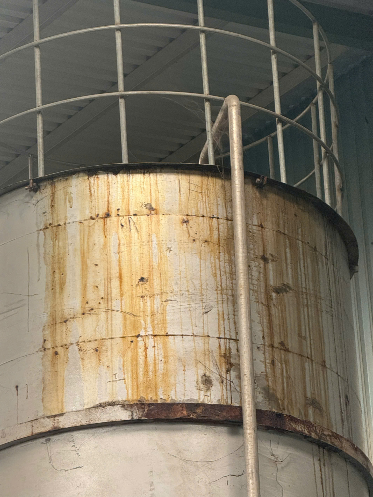Miệng silo thép chứa dịch đạm cá rỉ nặng, vệt dịch tràn chảy vàng nâu xuống thân silo